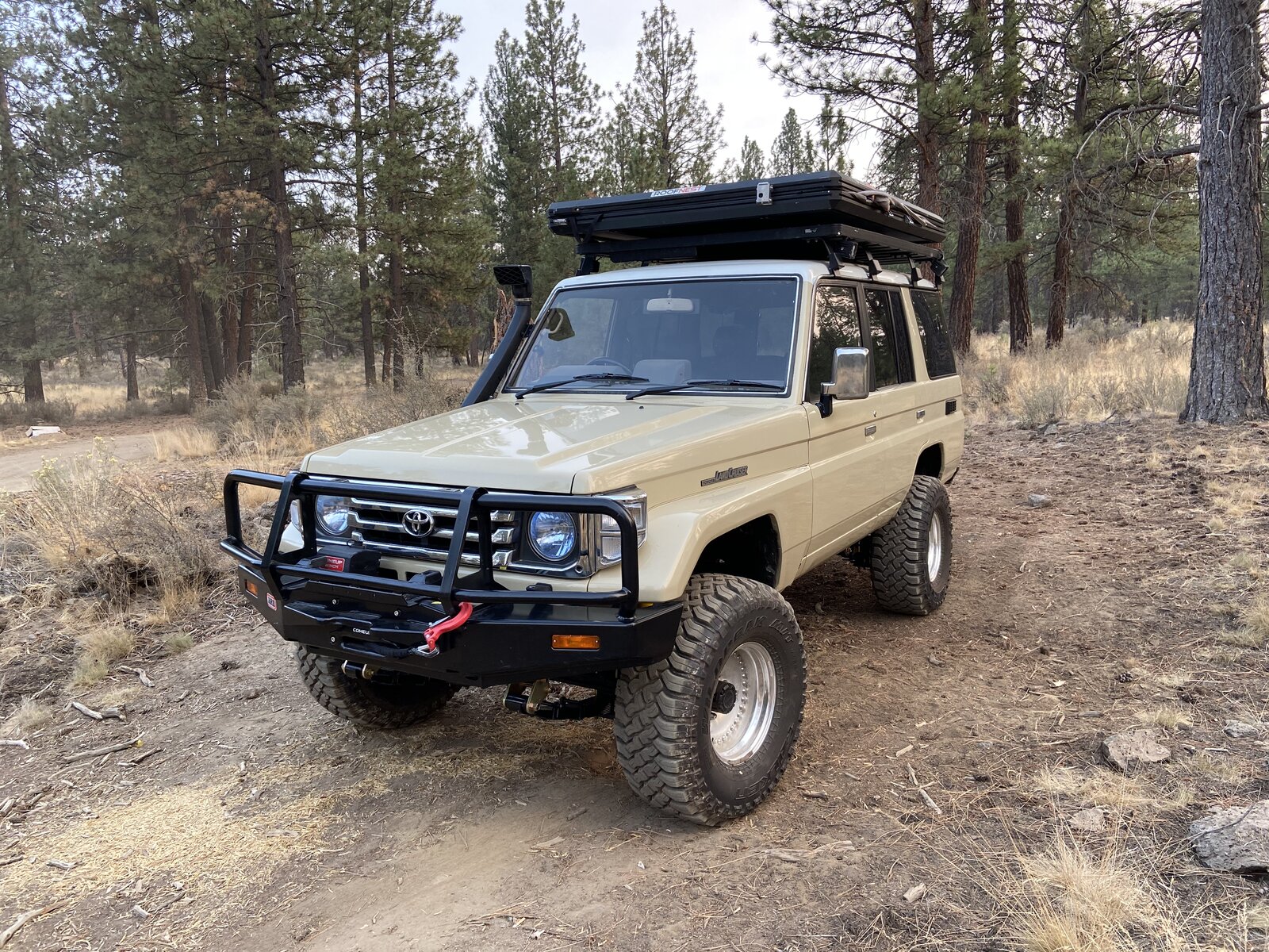 70 Series Land Cruiser with rooftop tent in the pines