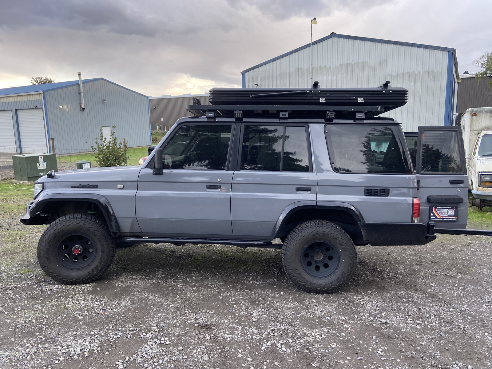 Gray Prado Land Cruiser with roof rack and awning