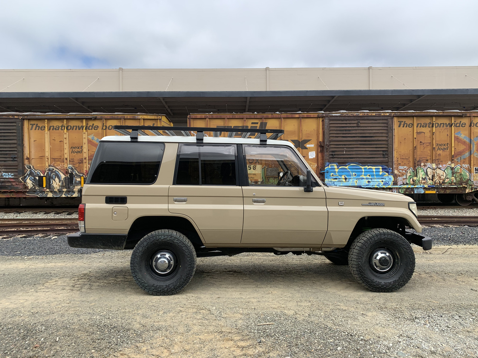 Gray Prado Land Cruiser in the snow with vintage wheels